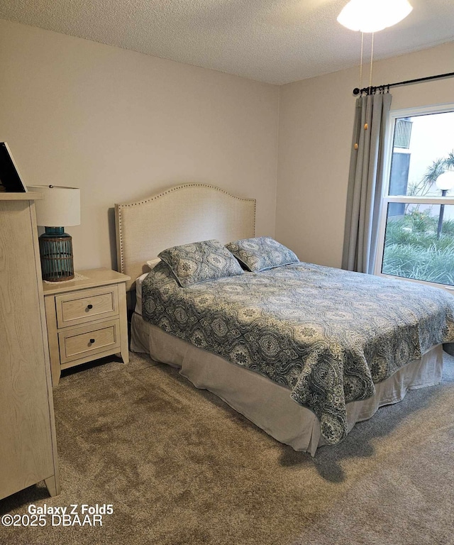 bedroom featuring a textured ceiling and dark carpet