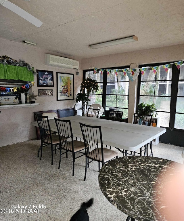 dining space with a wall mounted air conditioner and a textured ceiling