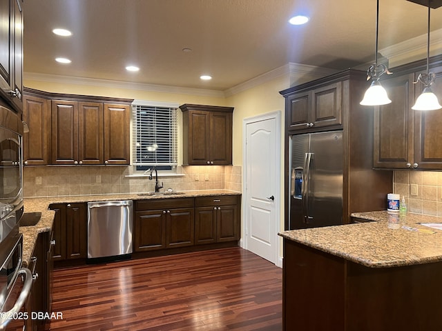 kitchen with crown molding, appliances with stainless steel finishes, dark wood-type flooring, a sink, and dark brown cabinetry