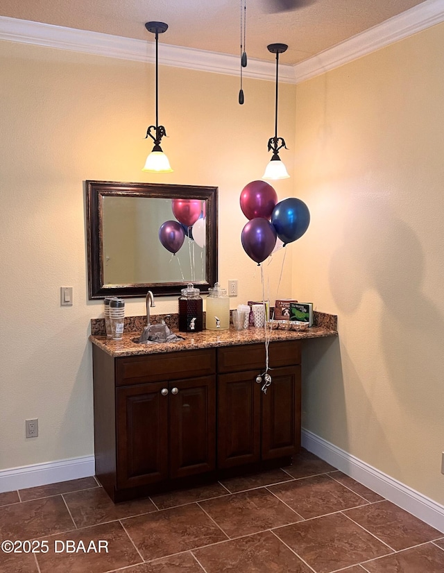 bar featuring ornamental molding, decorative light fixtures, a sink, and baseboards