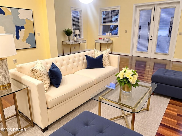 living room with french doors, baseboards, and wood finished floors