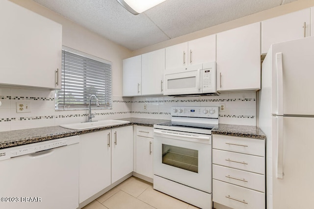 kitchen with white cabinets, white appliances, light tile patterned floors, and sink