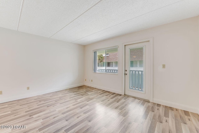 empty room featuring light hardwood / wood-style flooring and a textured ceiling