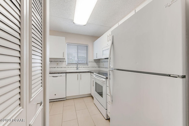 kitchen featuring white cabinets, white appliances, sink, and backsplash