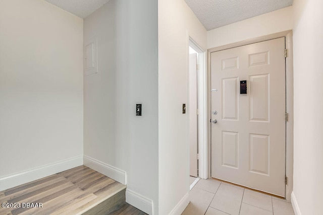 foyer entrance featuring light hardwood / wood-style floors and a textured ceiling