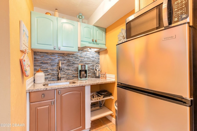 313 S Atlantic Avenue 302 & 304, Daytona Beach, FL 32118 - kitchen with stainless steel appliances, under cabinet range hood, backsplash, light tile patterned floors, and light stone counters
