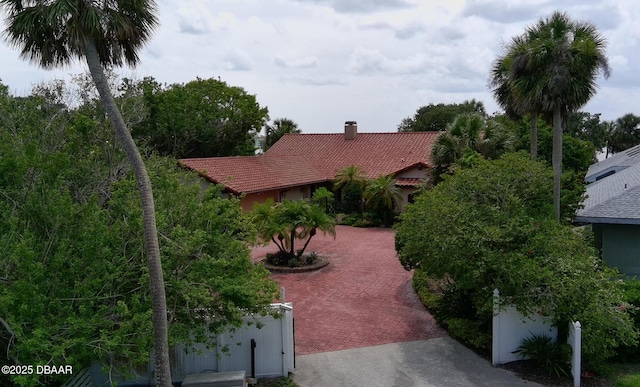 6 Rosalyn Lndg, Daytona Beach, FL 32118 - view of front of home featuring a chimney, a tiled roof, and decorative driveway
