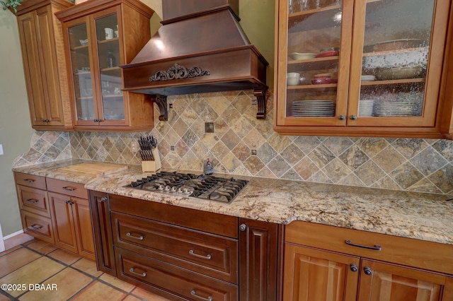 6 Rosalyn Lndg, Daytona Beach, FL 32118 - kitchen featuring premium range hood, stainless steel gas stovetop, decorative backsplash, and light stone counters