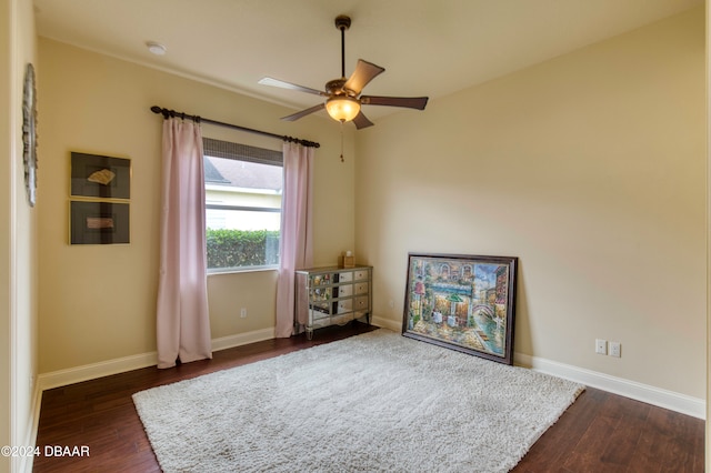 interior space with dark wood-type flooring and ceiling fan