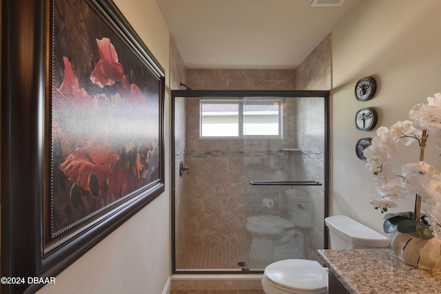 bathroom featuring an enclosed shower, vanity, and toilet