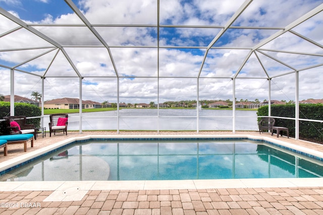 view of swimming pool with glass enclosure, a water view, and a patio