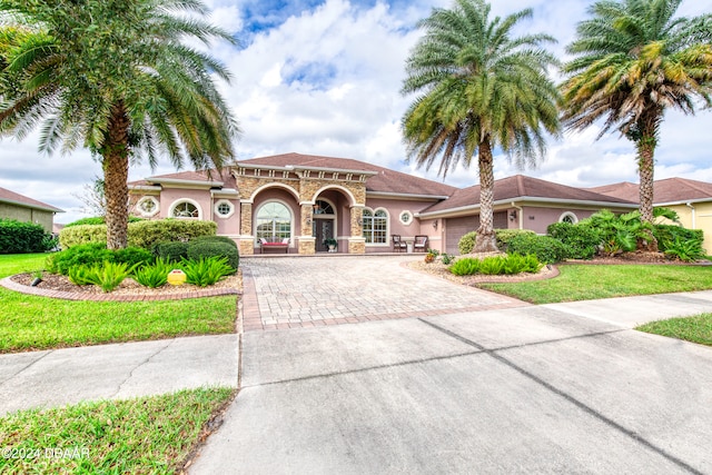 mediterranean / spanish house featuring a front lawn