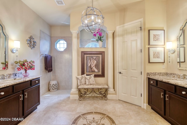 bathroom with vanity, tiled shower, a notable chandelier, decorative columns, and tile patterned floors