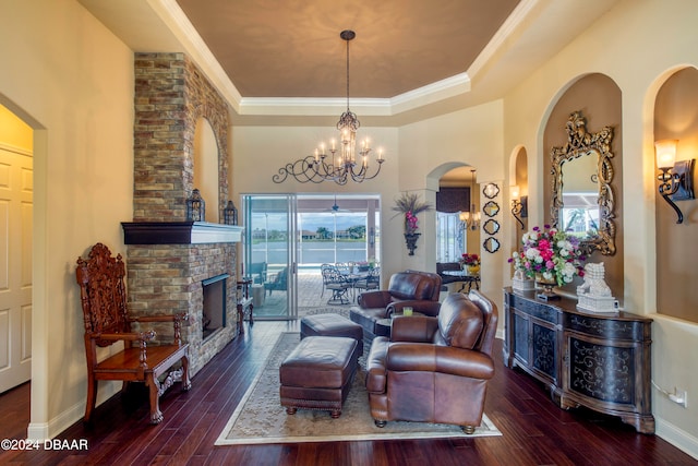 living room with ornamental molding, a fireplace, dark hardwood / wood-style flooring, and a raised ceiling