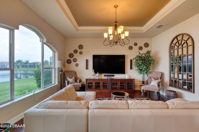 living room with a water view, wood-type flooring, a notable chandelier, and a healthy amount of sunlight