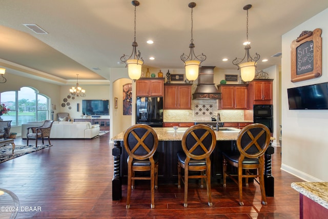 kitchen with dark wood-type flooring, black appliances, custom range hood, a breakfast bar, and backsplash