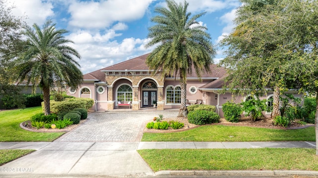 mediterranean / spanish house featuring a front lawn