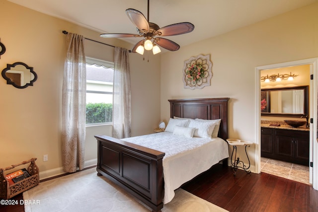 bedroom with ceiling fan, connected bathroom, sink, and light wood-type flooring