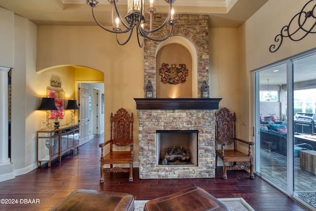 sitting room featuring dark wood-type flooring, a fireplace, a tray ceiling, and a towering ceiling