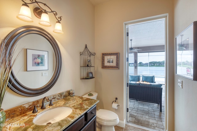 bathroom with toilet, vanity, tile patterned floors, and a water view