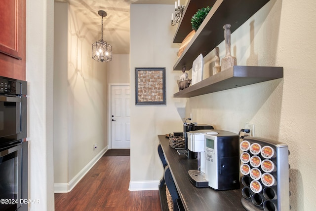 kitchen featuring pendant lighting, an inviting chandelier, double oven, and dark hardwood / wood-style floors