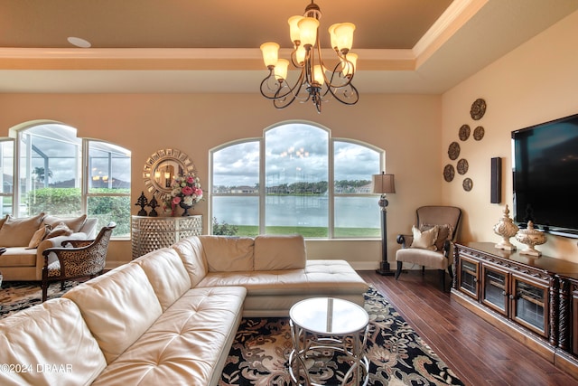 living room with dark wood-type flooring, a chandelier, plenty of natural light, and a raised ceiling