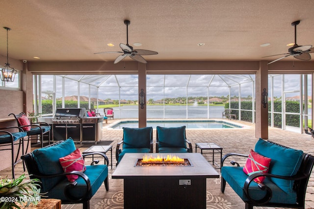 view of patio with a lanai, ceiling fan, and an outdoor living space with a fire pit