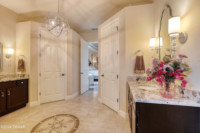 bathroom with tile patterned floors, vanity, and a notable chandelier