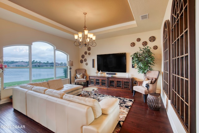 living room with a notable chandelier, dark hardwood / wood-style floors, and a tray ceiling