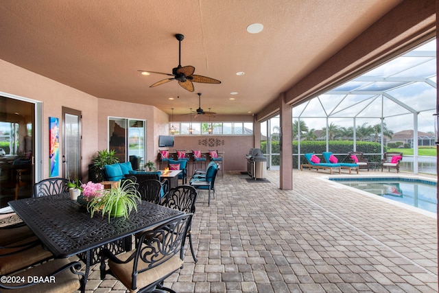 view of patio / terrace with glass enclosure, outdoor lounge area, and ceiling fan