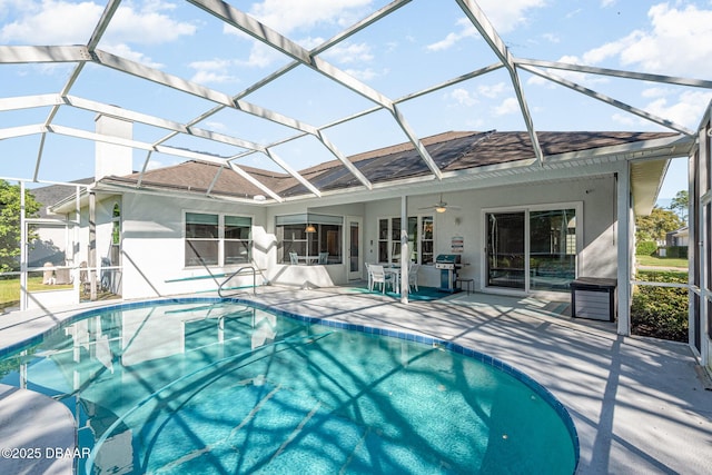 outdoor pool with a lanai, a patio area, and ceiling fan