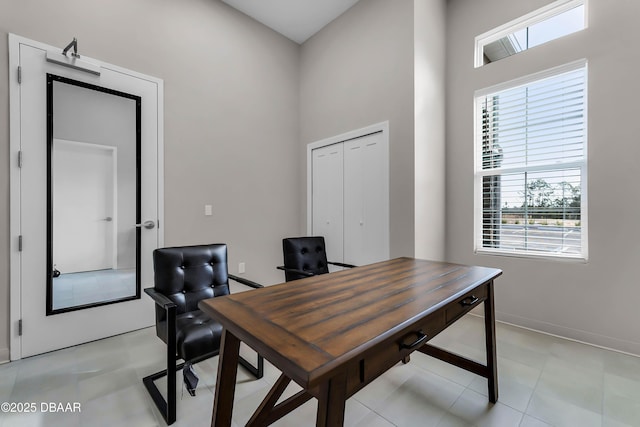 3330 Arch Ave, Ormond Beach, FL 32174 - office with light tile patterned floors, baseboards, a healthy amount of sunlight, and a high ceiling