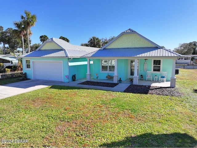 view of front of home with a front lawn, covered porch, and a garage