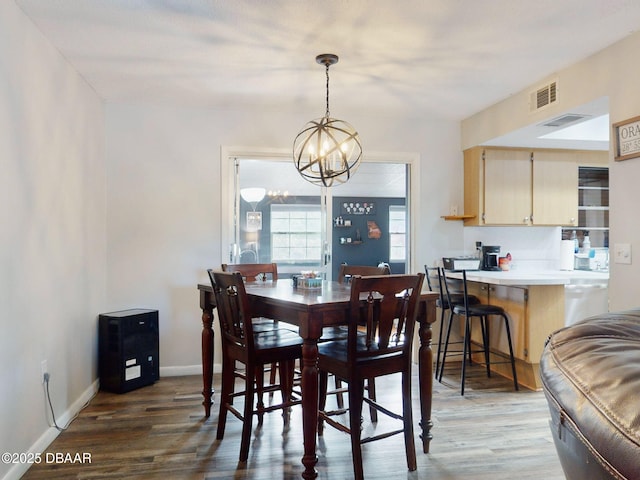 dining area with dark wood-style floors, baseboards, visible vents, and a notable chandelier