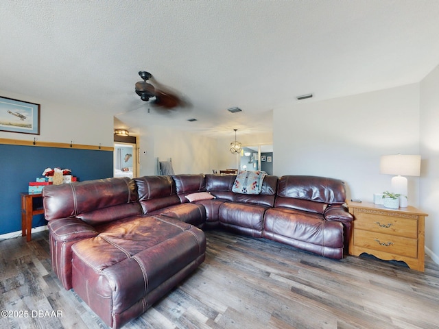 living room with dark wood-style flooring, visible vents, and a textured ceiling