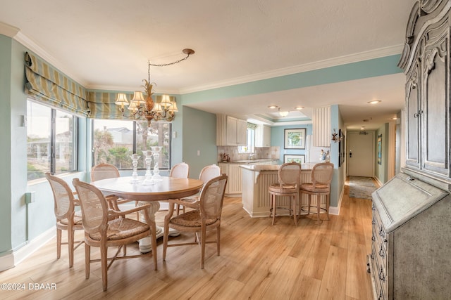 dining area featuring an inviting chandelier, light hardwood / wood-style flooring, and crown molding