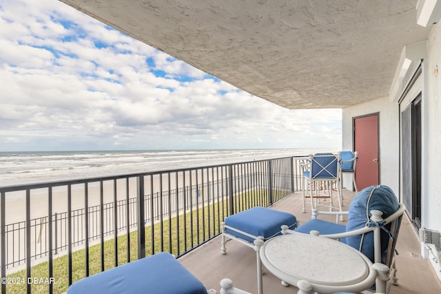 balcony with a water view and a beach view