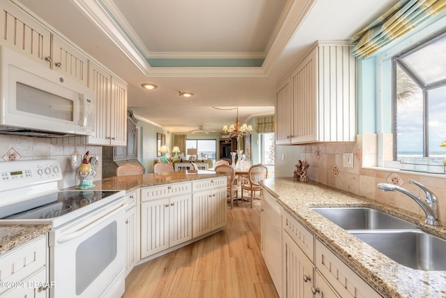 kitchen featuring a wealth of natural light, sink, white appliances, and light wood-type flooring