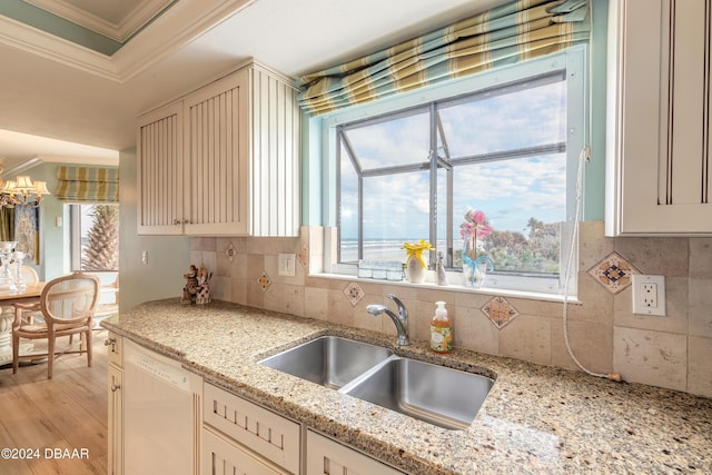 kitchen with light stone countertops, sink, crown molding, white dishwasher, and light wood-type flooring