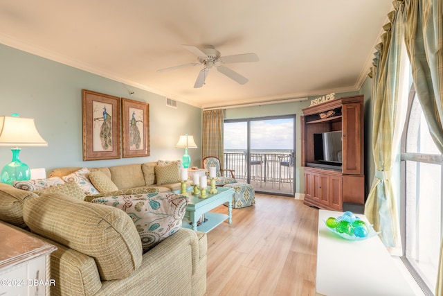 living room featuring ceiling fan, ornamental molding, and light wood-type flooring