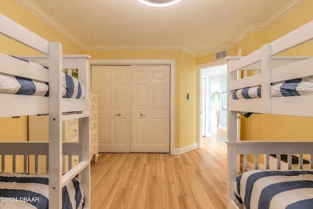 bedroom featuring light hardwood / wood-style flooring, a closet, and crown molding