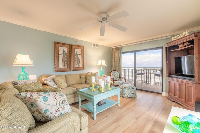 living room featuring ceiling fan, ornamental molding, and light wood-type flooring