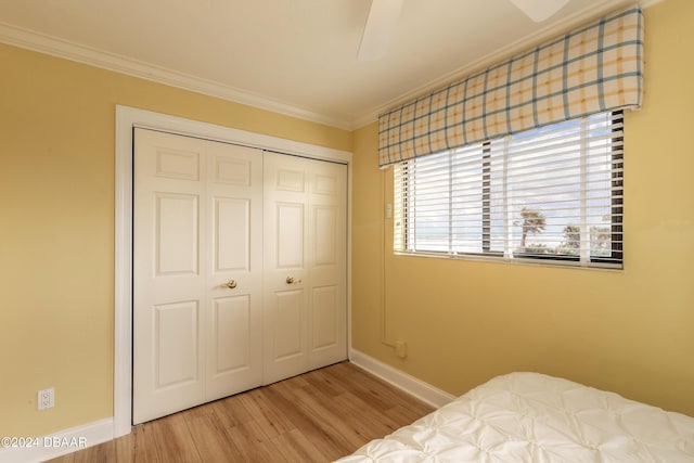 bedroom with light wood-type flooring, a closet, ornamental molding, and ceiling fan