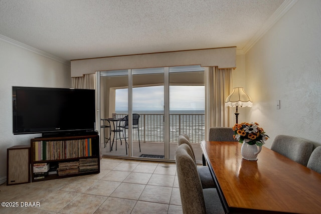 dining area with a water view, crown molding, a textured ceiling, and light tile patterned floors