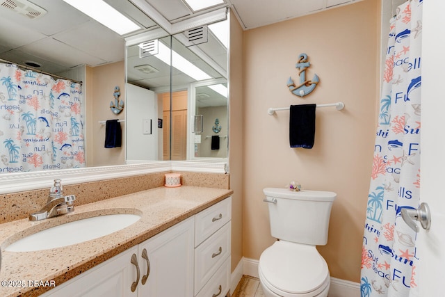 bathroom with toilet, vanity, and visible vents