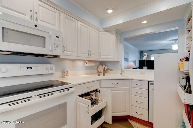 kitchen featuring crown molding, light countertops, white appliances, and white cabinets