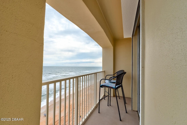 balcony with a beach view and a water view