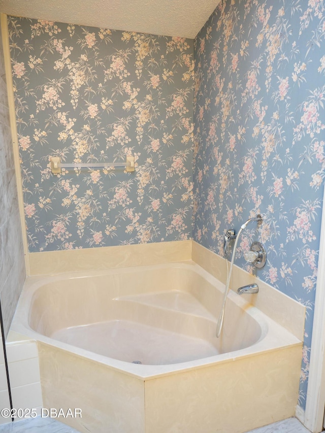 bathroom with a textured ceiling and a tub to relax in