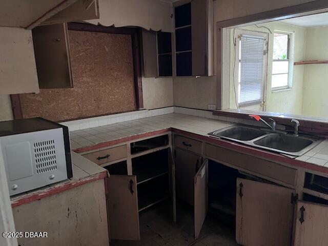 kitchen featuring tile counters and sink