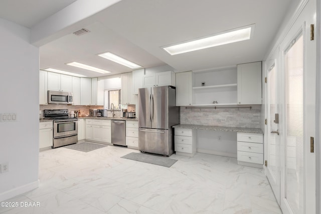 kitchen featuring stainless steel appliances, tasteful backsplash, light marble finish flooring, and open shelves
